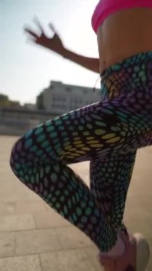 Spor giyim sektöründe genç ve hayat dolu bir bayan aydınlık bir yaz gününde şehir sokaklarında çalışıyor. Yüksek kalite 4k görüntü