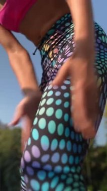 Sağlıklı, kulaklıklı genç bir kız şehir sokaklarında egzersiz yapıyor. Yüksek kalite 4k görüntü