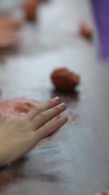 Çocuklar ahşap bir el sanatları masasında kille heykel yapıyorlar. Yüksek kalite 4k görüntü