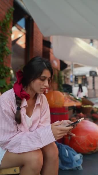Çiftçi Pazarında Pembe Elbiseli Akıllı Telefon Taşıyan Çekici Bir Genç — Stok video