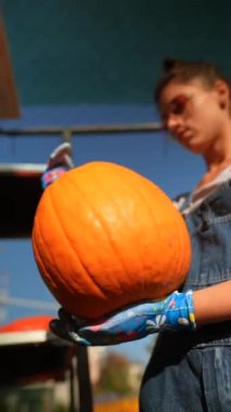 Canlı piyasa ortamında, bir bayan çiftçi elindeki balkabaklarını canlı bir şekilde sunuyor. Yüksek kalite 4k görüntü