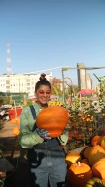 Canlı piyasa ortamında, bir bayan satıcı elindeki balkabaklarını canlı bir şekilde sunuyor. Yüksek kalite 4k görüntü