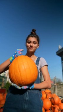 Çiftçi olarak çalışan bir kız, markette balkabaklarını sergilerken büyük bir hevesle görülüyor. Yüksek kalite 4k görüntü