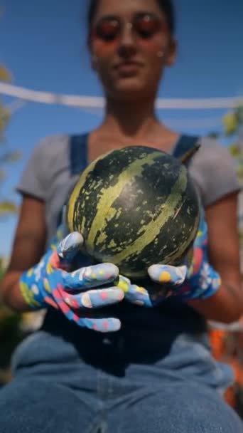 一个年轻的女人 作为一个农民 被看到展示一个绿色条纹南瓜 他们在市场上的库存 高质量的4K镜头 — 图库视频影像