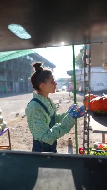 Pazar Yerinin Ortasında Genç Bir Dişi Çiftçi Gururla Satılık Balkabaklarının — Stok video