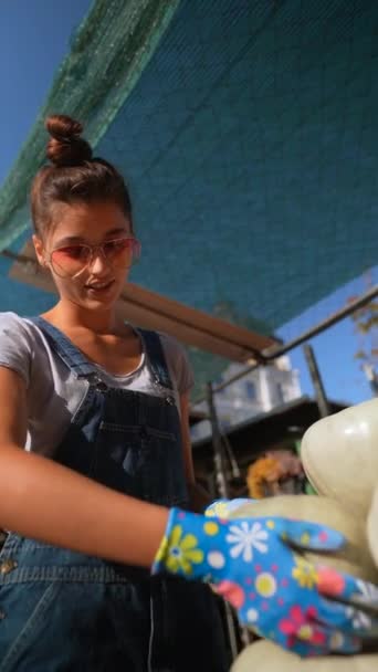 在市场上 一位充满活力的年轻女农场主骄傲地展示着她的南瓜 高质量的4K镜头 — 图库视频影像