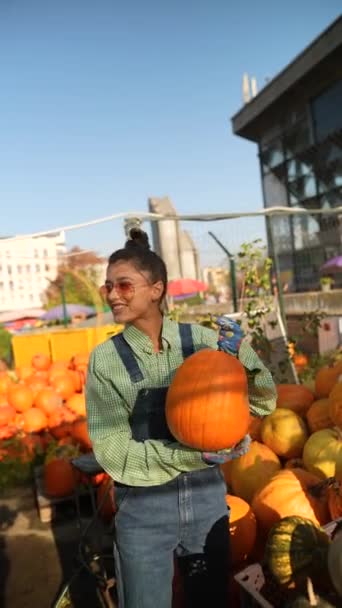 Una Joven Agricultora Está Mostrando Una Gran Calabaza Naranja Que — Vídeos de Stock