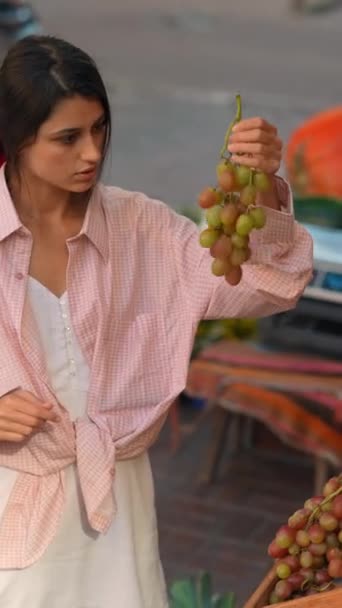 ピンクの服装の美しい若い女性は ヨーロッパの農家市場で果物を選択しています 高品質の4K映像 — ストック動画