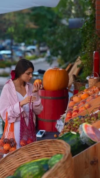 Μια Νεαρή Κοπέλα Ροζ Φιόγκο Στα Μαλλιά Αγοράζει Φρούτα Από — Αρχείο Βίντεο