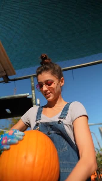 Amidst Market Scene Young Female Farmer Showcasing Sizable Orange Pumpkin — Stock Video