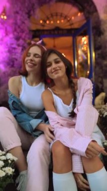 Leylak bahçesinde merdivenlerde oturan iki lezbiyen ortak. Yüksek kalite 4k görüntü