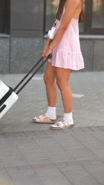 İki güzel, genç kadın ellerinde bir bavulla şehir yolunda ilerliyorlar. Yüksek kalite 4k görüntü