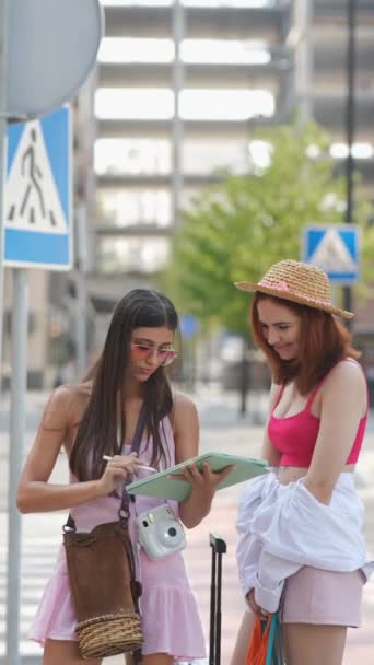 Twee Mooie Levendige Meisjes Kletsen Straat Met Een Tablet Tassen — Stockvideo