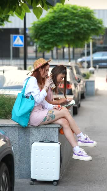 2人の素晴らしいファッショナブルな女性がストリートベンチに座り それぞれがタブレットに焦点を当てています 高品質の4K映像 — ストック動画