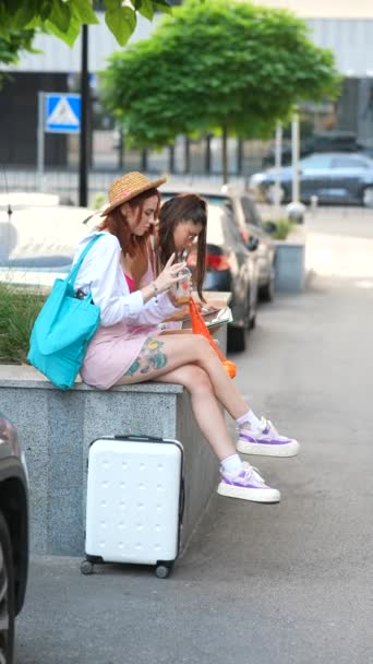 两个迷人的年轻女子坐在城里的长椅上 用的是平板电脑 高质量的4K镜头 — 图库视频影像