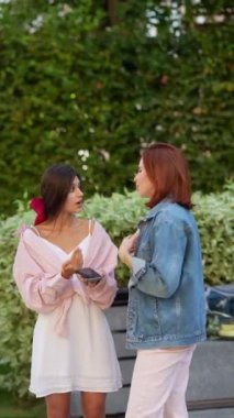 İki hareketli ve enerjik bayan parkta etkin bir şekilde sohbet ediyorlar. Yüksek kalite 4k görüntü