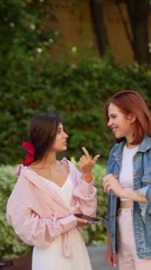 İki şık ve modaya uygun kadın şehir sokaklarında sohbet ediyor. Yüksek kalite 4k görüntü