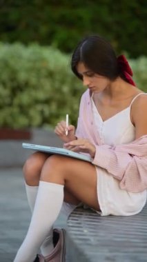 Yaz güneşinin altında tablet kullanan çarpıcı, genç bir kadın. Yüksek kalite 4k görüntü