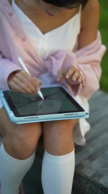 Açık havada bir yaz gününde tabletle çalışan genç ve güzel bir kadın. Yüksek kalite 4k görüntü