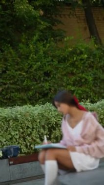  Yaz güneşinin altında tablet kullanan çarpıcı, genç bir kadın. Yüksek kalite 4k görüntü