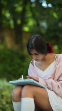 Yazın açık hava ortamında tablet kullanan güzel, genç bir kadın. Yüksek kalite 4k görüntü