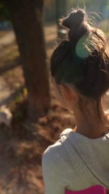 Sonbaharda, spor giyimli genç bir kadın köpeğiyle parkta yürüyüşe çıkıyor. Yüksek kalite 4k görüntü