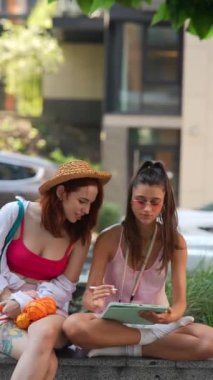 İki çekici, genç kız şehir sokaklarında çalışırken tablet kullanıyorlar. Yüksek kalite 4k görüntü