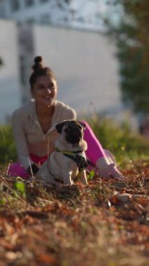 Neşeli genç bir bayan ve köpeği güz parkında sabah yürüyüşü yaparken görüldü. Yüksek kalite 4k görüntü