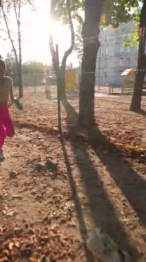 Dinamik genç bir bayan köpeğiyle parkta koşuyor. Yüksek kalite 4k görüntü