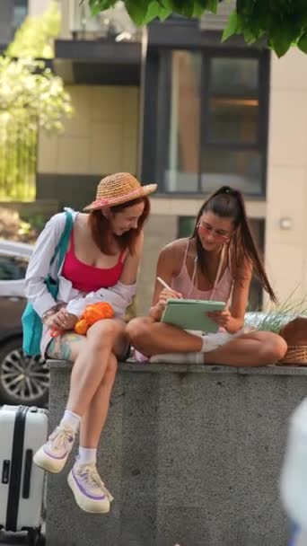 Two Exuberant Young Girls Seated Street Summer Day Using Tablets — Stock Video