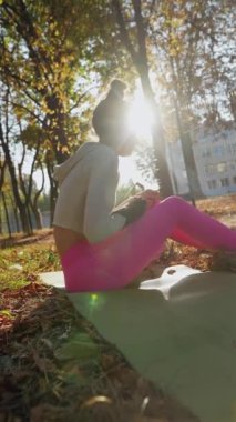 Bir sonbahar günü, neşeli genç bir bayan parkta köpeğini kucaklıyor. Yüksek kalite 4k görüntü