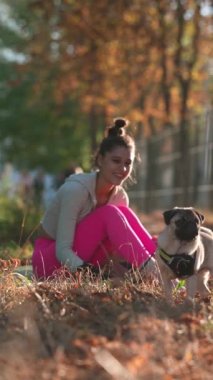 Sonbahar parkında bir sabah yürüyüşü sırasında, parlak, genç bir kadın köpeğiyle oyun oynamaktan zevk alır. Yüksek kalite 4k görüntü