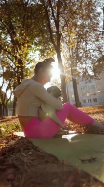 Sonbahar manzarasının ortasında, keyifli genç bir kadın ve köpeği sevgi dolu bir kucaklaşmayı paylaşıyor. Yüksek kalite 4k görüntü