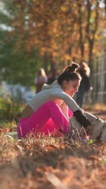 Genç bir kadın, köpeğiyle oynarken sarı yaprakların arasında neşe buluyor. Yüksek kalite 4k görüntü