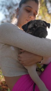 Spor giyimli bir kız güneşli bir sonbahar sabahında köpeğiyle geziyor. Yüksek kalite 4k görüntü