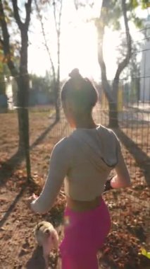 Park manzarasının ortasında enerjik bir kadın köpeğiyle birlikte koşarken görüldü. Yüksek kalite 4k görüntü