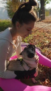 Güneşli bir sabah parkta, çekici genç bir kadın köpeğiyle eğleniyor. Yüksek kalite 4k görüntü