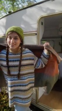 Sonbahar yapraklarının arasında, battaniyeye sarılmış çekici bir kız sohbet ediyor. Yüksek kalite 4k görüntü