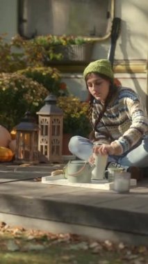 Hipster yeteneğiyle, canlı bir kız karavanın yanına oturmuş, hoş sonbahar havasının tadını çıkarıyor. Yüksek kalite 4k görüntü