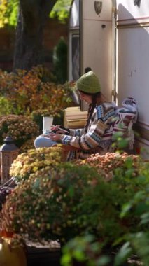 Bir hipster meraklısı açık havada tabletini kullanarak, bir sonbahar gününün güneşli atmosferini ve işini kusursuz bir şekilde harmanlıyor. Yüksek kalite 4k görüntü