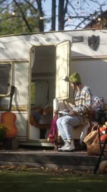 Hipster tarzını benimseyen şık ve ışıl ışıl genç bir bayan, sonbaharda güneşli bir günde tablet üzerinde çalışırken görülüyor. Yüksek kalite 4k görüntü