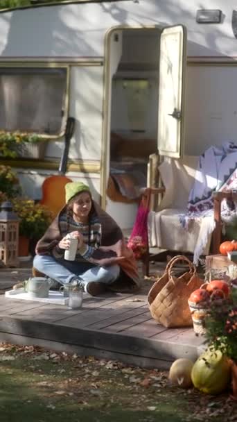 一个充满活力的嬉皮士女孩坐在拖车旁边 享受着美妙的秋天天气 高质量的4K镜头 — 图库视频影像