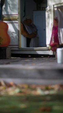 Sarı yapraklı bir genç kız karavanın yanında dans ediyor. Yüksek kalite 4k görüntü