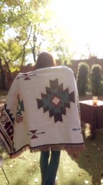 Havalı ve genç bir kadın, hippi yaşam tarzına tamamen dalmış, güneşli sonbahar havasından zevk alıyor. Yüksek kalite 4k görüntü