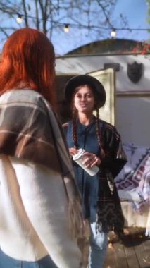 Göz kamaştırıcı hippi cazibesiyle, büyüleyici kızlar bahçedeki güneşli sonbahar gününün tadını çıkarıyorlar. Yüksek kalite 4k görüntü