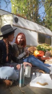 Hippiler gibi giyinmiş güzel kızlar bahçedeki güneşli sonbahar gününün tadını çıkarıyorlar. Yüksek kalite 4k görüntü