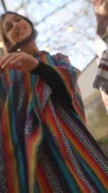 Hippi gibi giyinmiş bir çift genç kız sonbahar bahçesinde dans ediyorlar. Yüksek kalite 4k görüntü