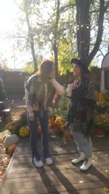 Göz kamaştırıcı genç hanımlar, hippi havalarıyla bahçedeki güneşli sonbahar gününün tadını çıkarıyorlar. Yüksek kalite 4k görüntü