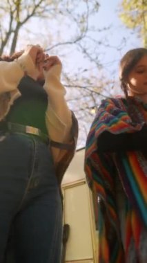 Hippi kıyafetleriyle, güzel ve genç kızlar güneşli bir sonbahar gününde dans ederken görülür. Yüksek kalite 4k görüntü