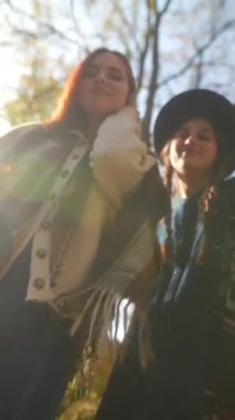 Sonbahar bahçesinde hippi kıyafetli iki genç kız dans ediyor. Yüksek kalite 4k görüntü